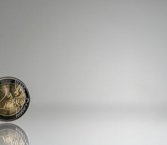 통장 잔고와 마음 건강의 상관관계, 재정적 웰니스 a close up of a coin on a reflective surface