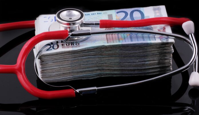 Photo by Marek Studzinski a medical stethoscope resting on a stack of money