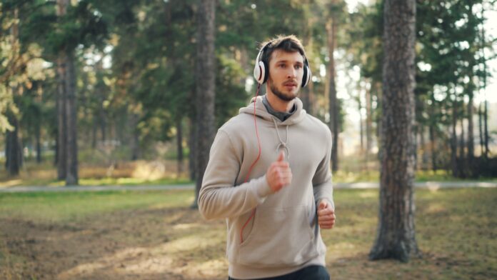 Photo by Vitaly Gariev Man with headphones running in a forest