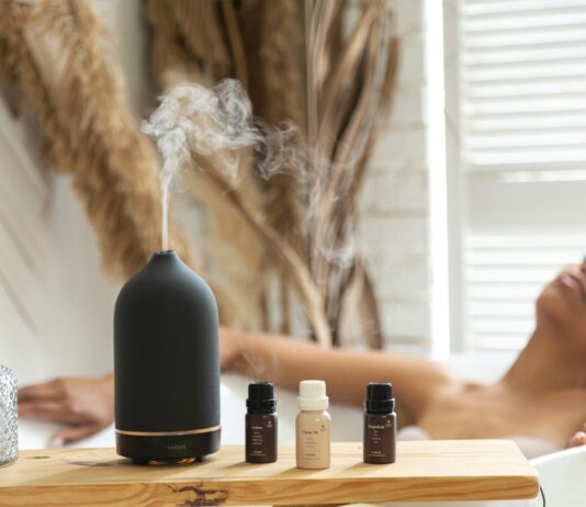 일상 속 대체요법, 작은 실천이 건강을 바꾼다 a woman laying in a bathtub next to a bottle of essential oils