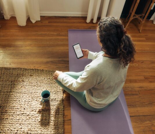 스트레스, 일상 속 작은 변화로 관리한다…최근 주목받는 ‘마이크로 습관’ 실천법 Woman meditating on yoga mat with phone and drink.