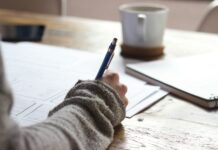 “끊이지 않는 피로감, ‘만성피로’ 극복하는 생활 속 작은 변화” person writing on brown wooden table near white ceramic mug